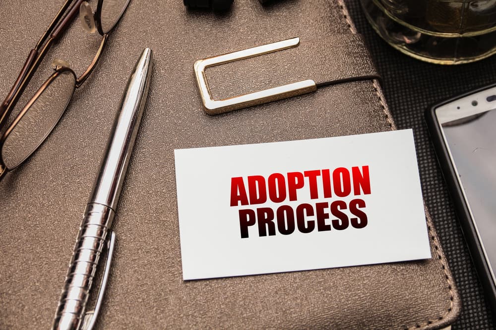 Adoption process written on a paper lying over a diary 